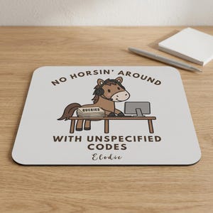 May include: A square mousepad with a light gray background featuring a cartoon brown horse wearing a headset at a desk with a computer and a stack of papers labeled QUERIES. The text reads NO HORSIN' AROUND WITH UNSPECIFIED CODES and Elodie.