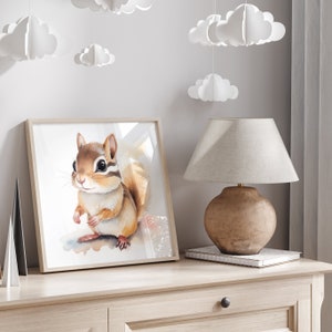 Könnte beinhalten: Ein Aquarellbild eines braunen und weißen Streifenhörnchens mit einem hellbraunen Schwanz. Das Streifenhörnchen steht auf einem weißen Hintergrund mit einem hellblauen Aquarell-Wasch.