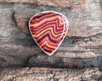 Púa de guitarra de tres capas, hecha a mano y con diseño personalizado.