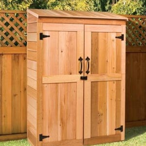 Pode incluir: Um galpão de armazenamento de madeira com duas portas e um telhado inclinado. O galpão é feito de madeira de cedro natural e tem dobradiças e alças de metal preto.