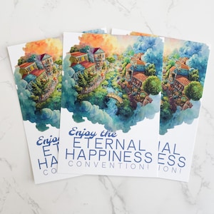 Op de afbeelding: Drie ansichtkaarten met een aquarel illustratie van een dorp in de wolken. De afbeelding toont gebouwen met rode daken, een brug en weelderig groen. De tekst "Enjoy the ETERNAL HAPPINESS CONVENTION" is blauw gedrukt.