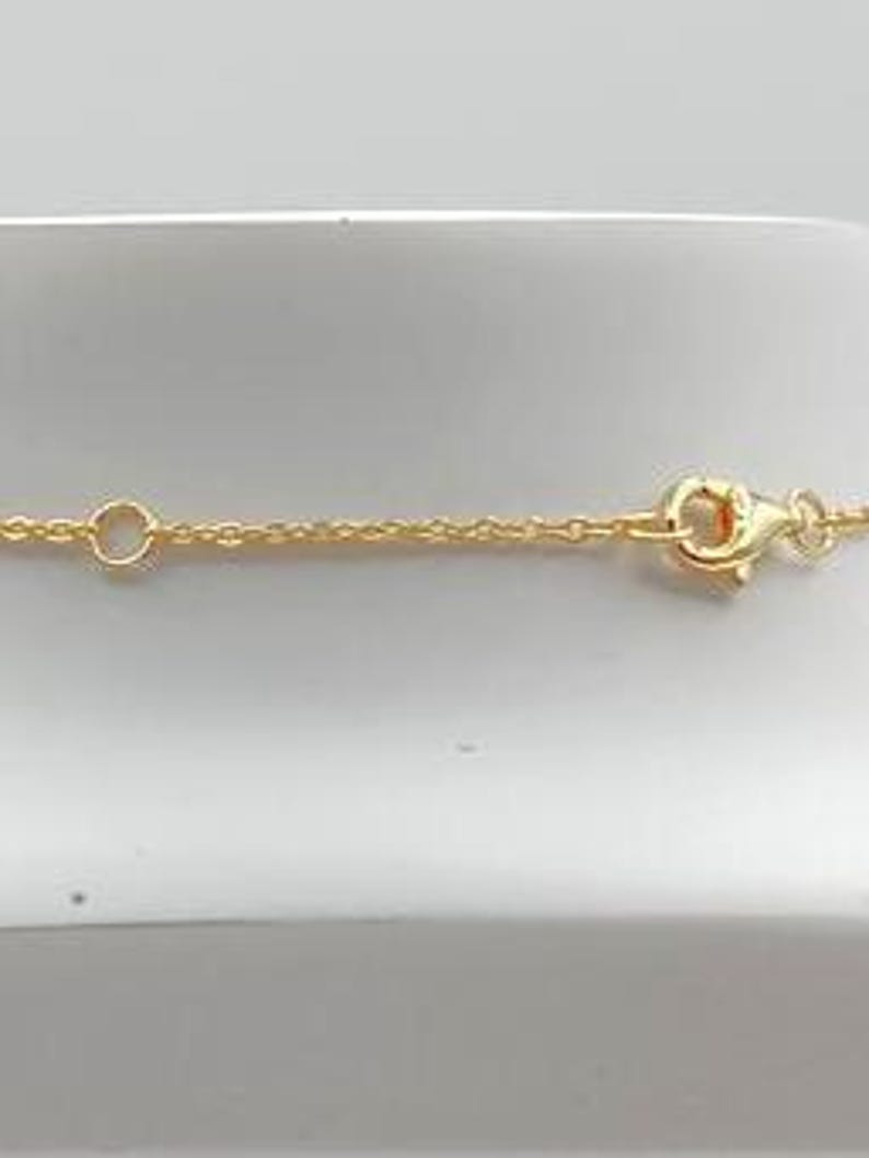 May include: A gold chain necklace with a lobster clasp closure.