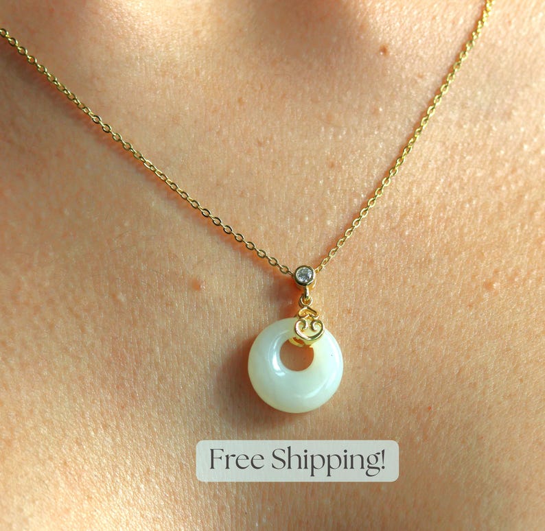 May include: A gold chain necklace with a white round pendant featuring a small gold heart charm. The pendant has a hole in the center.  Free Shipping!