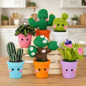 May include: A selection of knitted plant plushies, including cacti and other plants, in a variety of colours. The plushies are in colourful pots with smiling faces. The background is a wooden surface. The plants include a green cactus, a pink succulent, and a tree with white flowers.