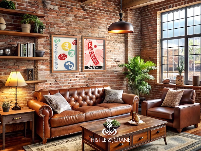 May include: A living room featuring a brown leather sofa and armchair, a wooden coffee table, and a brick wall. Two framed Japanese art prints are displayed above the sofa. A lamp and shelves with books and plants complete the decor.