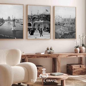 May include: Three framed black and white wall art prints depicting historical architectural scenes with water, statues, and people in period clothing. The prints are displayed in light wood frames and hung in a horizontal row on a plain wall.