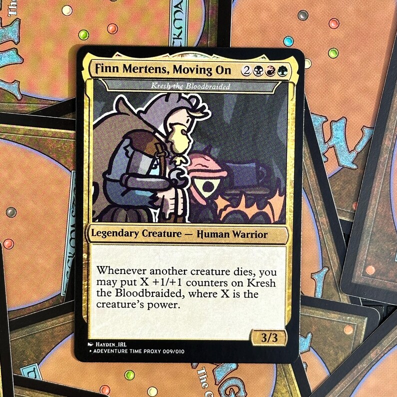 Peut inclure: Une carte Magic: The Gathering personnalis&eacute;e avec Finn Mertens de Adventure Time. La carte a une bordure dor&eacute;e et comprend le texte "Finn Mertens, Moving On" et "Kresh the Bloodbraided". La carte est une cr&eacute;ature l&eacute;gendaire - Human Warrior.