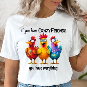 May include: White t-shirt with a graphic of three cartoon chickens. The text "if you have CRAZY FRIENDS you have everything" is printed on the shirt.