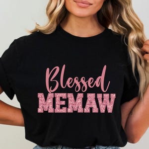K&ouml;nnte beinhalten: Schwarzes T-Shirt mit dem Text "Blessed Memaw" in pinkfarbenem Glitzer.