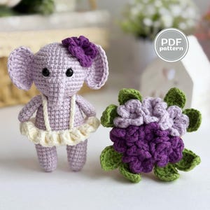 May include: A crocheted lavender elephant with a purple bow and a cream-colored tutu stands next to a crocheted purple flower with green leaves. The image includes a "PDF pattern" logo.