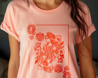 Könnte beinhalten: Ein pinkfarbenes T-Shirt mit einer roten Grafik einer Herzdame Spielkarte. Die Dame hält eine Rose und trägt eine Krone.