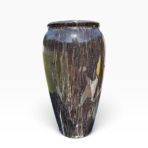 May include: A tall, cylindrical ceramic vase with a glossy, dark brown glaze featuring vertical, streaky drip patterns in shades of white, light blue, and yellow. The vase has a smooth, rounded rim and a tapered base, showcasing a reflective finish.
