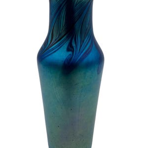 May include: A tall, slender blue glass vase with a swirling iridescent pattern. The vase has a narrow neck and a wide base.