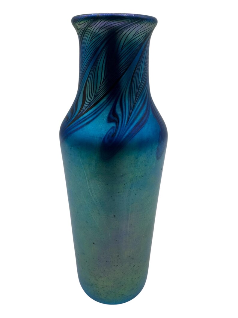 May include: A tall, slender blue glass vase with a swirling iridescent pattern. The vase has a narrow neck and a wide base.