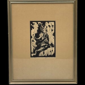 May include: Black and white woodcut print of a figure in armor, framed in a silver frame. The print is signed "Ruth Taylor" and dated "1938".