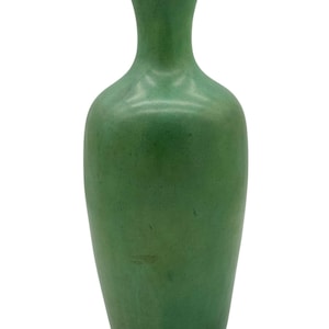 May include: A green ceramic vase with a rounded body and a narrow neck. The vase has a smooth, glossy finish.