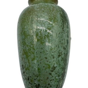 May include: A green ceramic vase with a textured surface. The vase has a bulbous body and a narrow neck. The color is a mix of light and dark greens, with a speckled pattern. The vase is a decorative item.