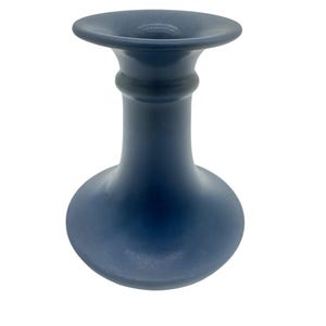 May include: A matte navy blue candle holder with a wide, flared top rim, a slender neck featuring a single horizontal ring detail, and a rounded, bulbous base. The object has a smooth, uniform finish and a symmetrical, vertical structure.