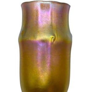 Puede incluir: Un jarrón de vidrio iridiscente con una superficie texturizada y nervada. El jarrón es de color ámbar oscuro con toques de morado y rosa.