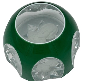 May include: A green glass sphere with clear glass panels. The sphere has a white interior and a white rim around the clear panels.