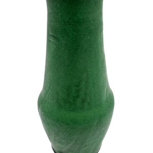 May include: A green, textured vase with a slightly flared top and a rounded base. The vase has a smooth, matte finish and a simple, elegant design. The vase is approximately 8 inches tall.