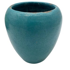 Könnte beinhalten: Eine tealblaue Keramikvase mit abgerundeter, leicht ovaler Form. Die Vase hat eine glatte, leicht strukturierte Oberfläche.