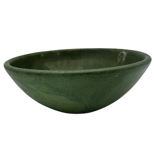 May include: A handcrafted, oval-shaped bowl with a textured, dark green surface. The bowl has a smooth interior and a slightly uneven rim. The color is a deep, earthy green, suggesting a natural, organic aesthetic. This bowl is suitable for serving or display.