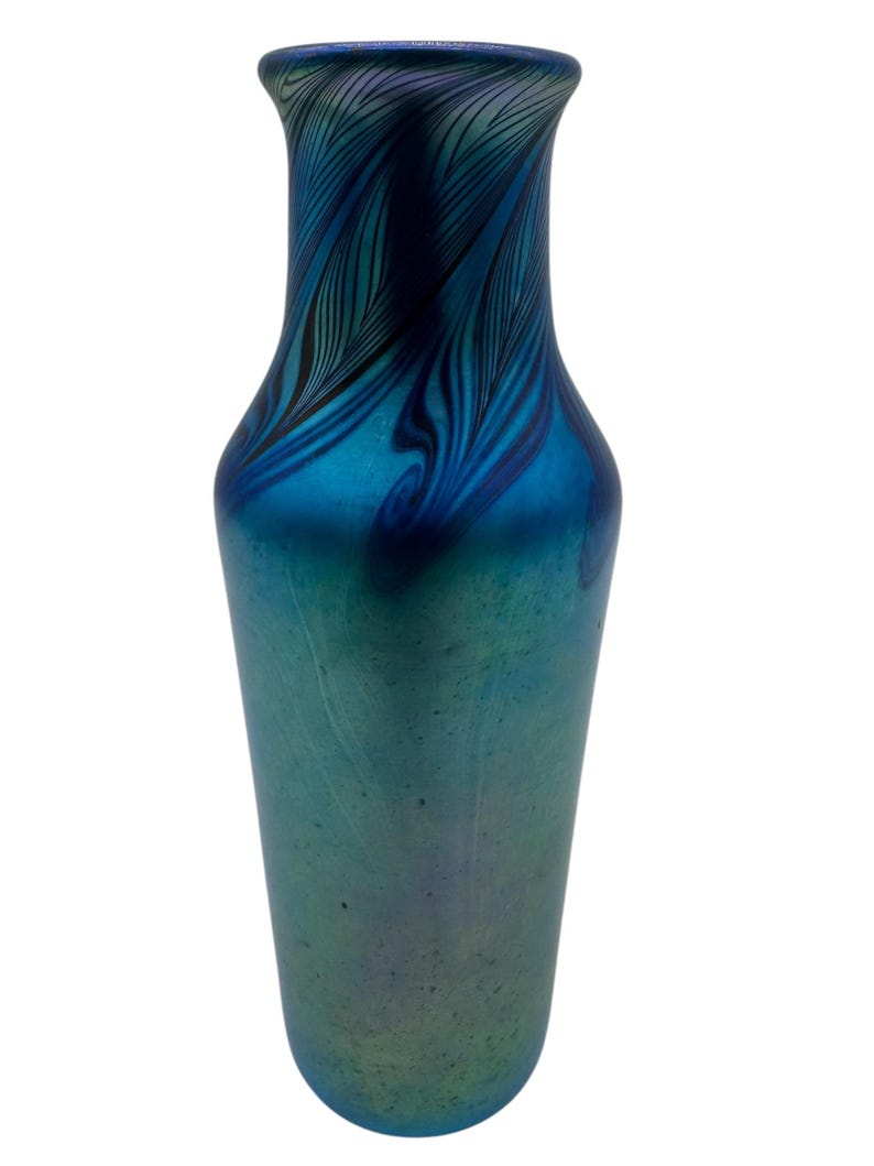 May include: A blue iridescent glass vase with a swirling pattern. The vase has a narrow neck and a wide base.