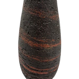 May include: A dark brown, textured vase with horizontal bands of reddish-brown. The vase has a rounded, elongated shape, tapering towards the top. The surface appears rough and porous, giving it a rustic appearance. The vase is likely made of ceramic or a similar material.