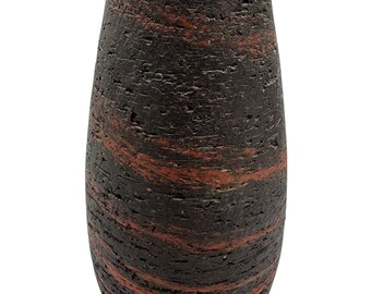 May include: A dark brown, textured vase with horizontal bands of reddish-brown. The vase has a rounded, elongated shape, tapering towards the top. The surface appears rough and porous, giving it a rustic appearance. The vase is likely made of ceramic or a similar material.