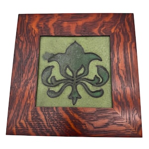 Könnte beinhalten: Quadratische, gerahmte Kunst mit einem grünen floralen Design auf grünem Hintergrund. Der Rahmen besteht aus dunkelbraunem Holz mit sichtbarem Maserungsmuster. Das Kunstwerk ist im Rahmen zentriert.