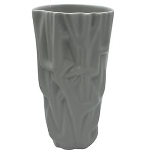 May include: A gray ceramic vase with a textured, organic design. The vase has a tall, cylindrical shape with a slightly flared top. The surface features a series of overlapping, abstract shapes, creating a unique, sculptural appearance. The vase is suitable for displaying flowers or as a decorative accent.