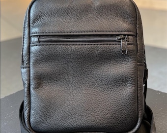 Bolso bandolera de cuero con acceso rápido y tirador para transporte oculto.