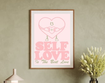May include: A framed pink print with the words "SELF LOVE Is The Best Love". The artwork features a cartoon heart embracing itself. The print is in a wooden frame and is displayed on a wooden cabinet.