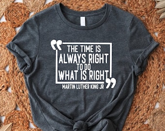 Pode incluir: Uma camiseta cinza escura com uma citação branca que diz "O tempo sempre está certo para fazer o que é certo" com a atribuição "Martin Luther King Jr." abaixo da citação.