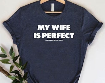 May include: A dark blue t-shirt with white text that reads "My wife is perfect (She bought me this shirt)"
