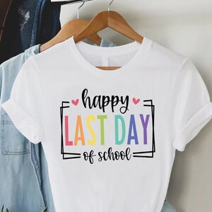 May include: White t-shirt with the text "happy last day of school" in a rainbow colour scheme.