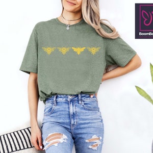 a woman wearing a green shirt and ripped jeans