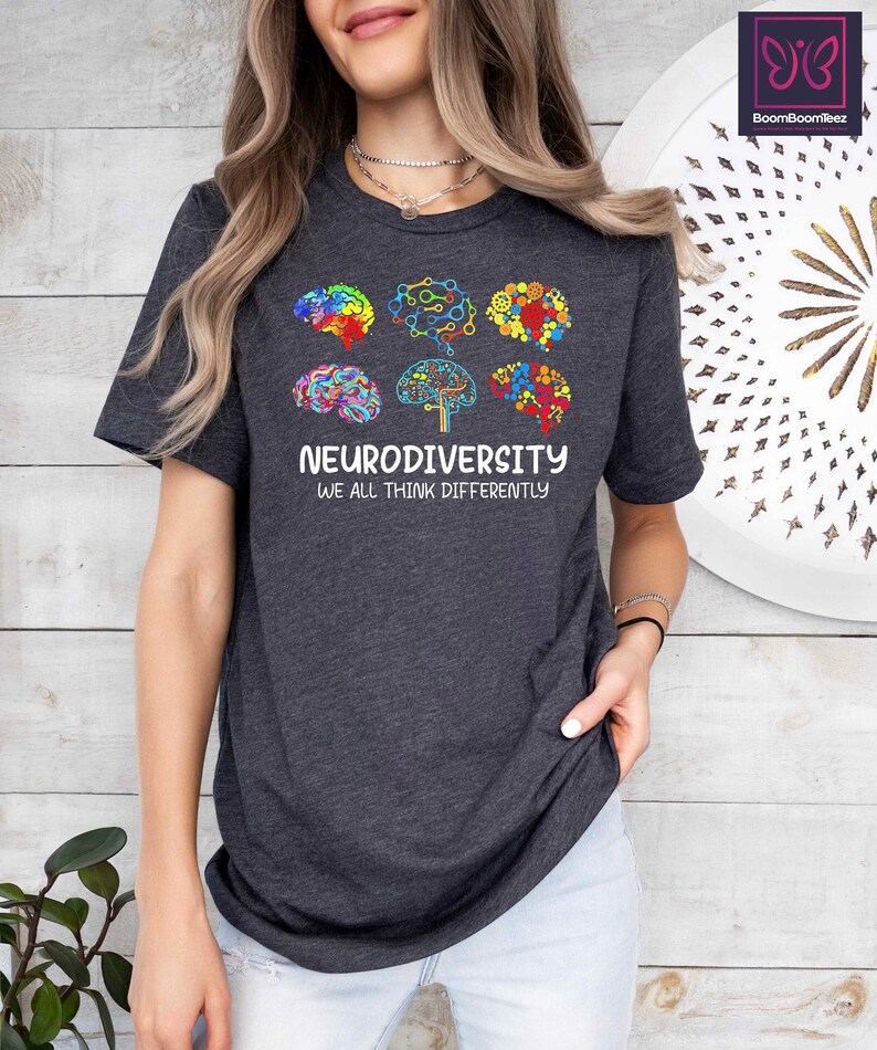 K&ouml;nnte beinhalten: Ein dunkelgraues T-Shirt mit einer Grafik aus bunten Hirn-Umrei&szlig;ungen und dem Text "Neurodiversity We All Think Differently".