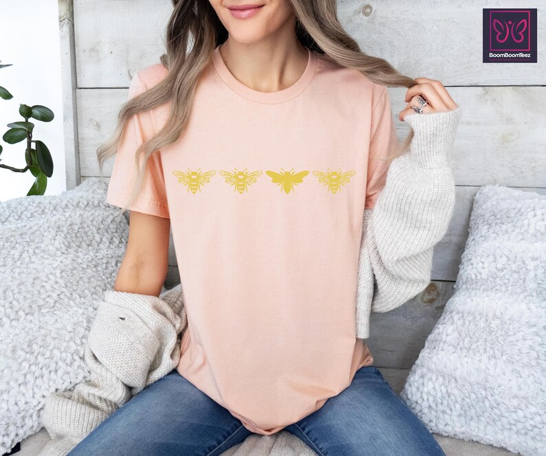 a woman sitting on a bed wearing a pink shirt