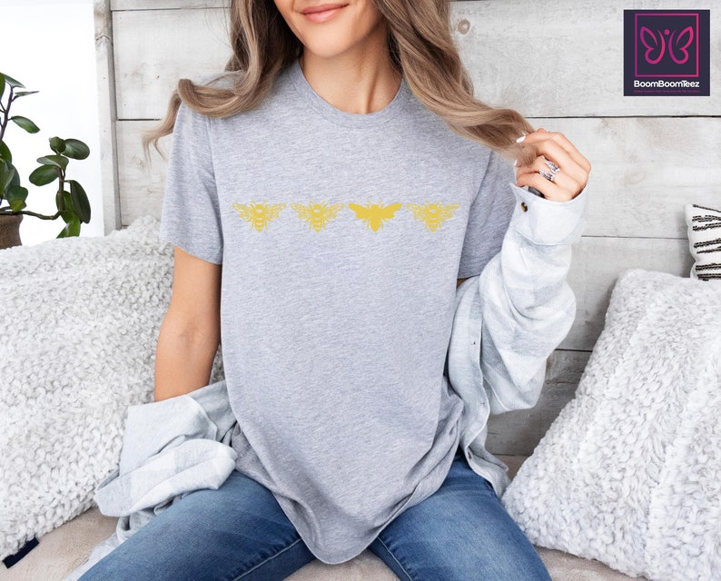 a woman sitting on a bed wearing a grey shirt