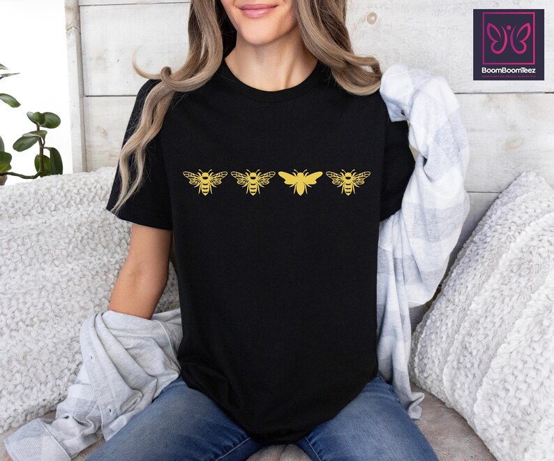 a woman sitting on a couch wearing a black shirt with yellow butterflies on it