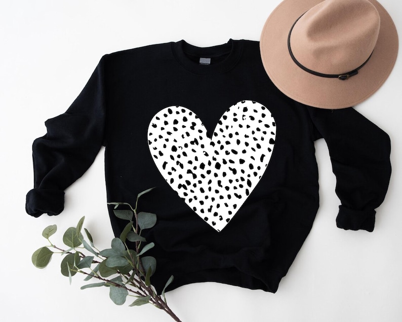 a black sweater with a white heart on it