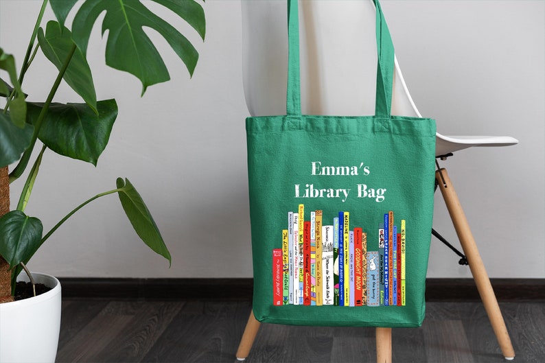 May include: Green canvas tote bag with the text "Emma's Library Bag" and a colorful illustration of a stack of books.