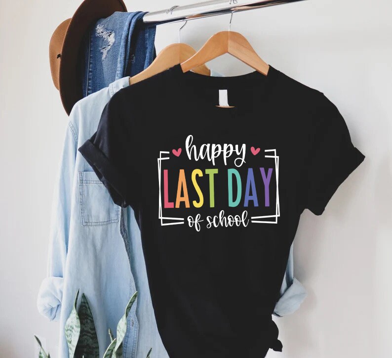 May include: Black t-shirt with the text "happy last day of school" in a rainbow font with pink hearts.
