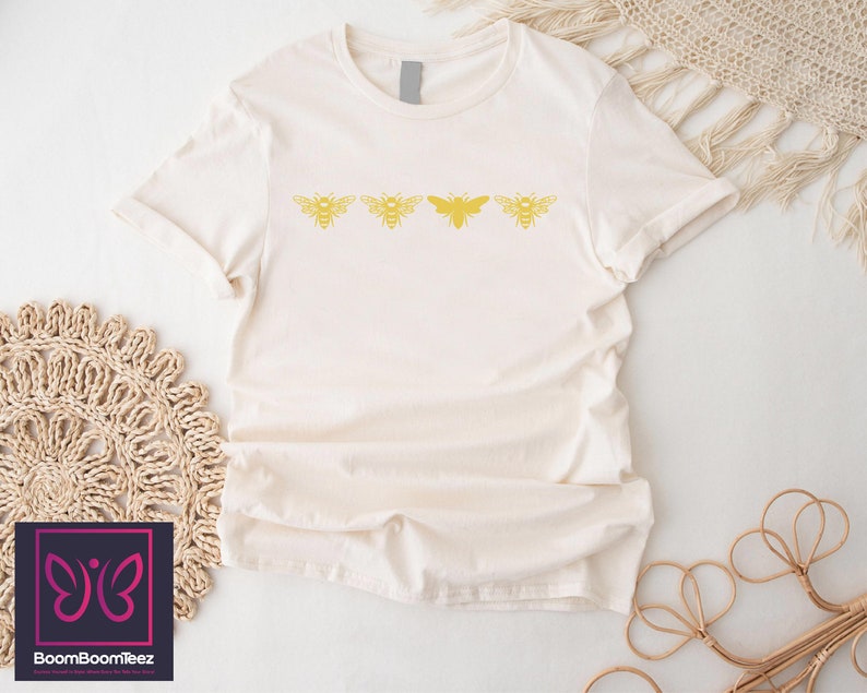 a white t - shirt with a yellow butterfly on it