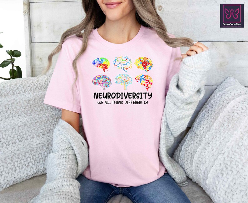K&ouml;nnte beinhalten: Pinkes T-Shirt mit einer Grafik von bunten Hirn-Umrei&szlig;ungen und dem Text "Neurodiversity We All Think Differently".