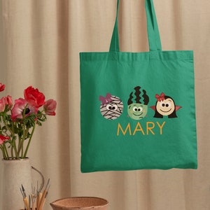 a person holding a green bag with two birds on it