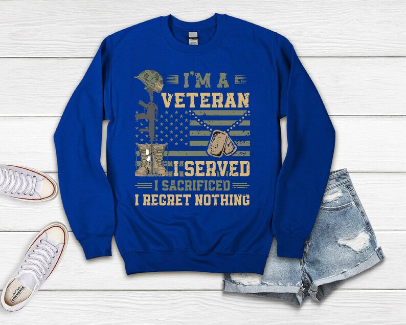 以下が含まれることがあります： ロイヤルブルーのスウェットシャツに、白と黒で「I'm a Veteran I Served I Sacrificed I Regret Nothing」の文字が書かれています。デザインには、迷彩柄の兵士のヘルメット、ライフル、ドッグタグが含まれています。