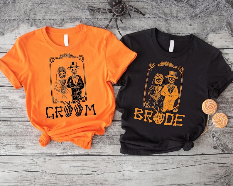 a couple of t - shirts sitting on top of a wooden table